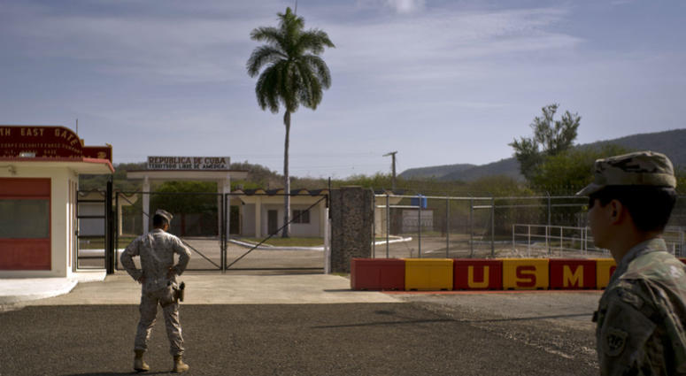 In this Wednesday, June 6, 2018 photo, reviewed by U.S. military officials, an Army soldier, right, and a Marine stand in front of the gates that separate the Cuban side from the Guantanamo Bay U.S. Naval Base. an Army soldier, right, and a Marine stand in front of the gates that separate the Cuban side from the Guantanamo Bay U.S. Naval Base