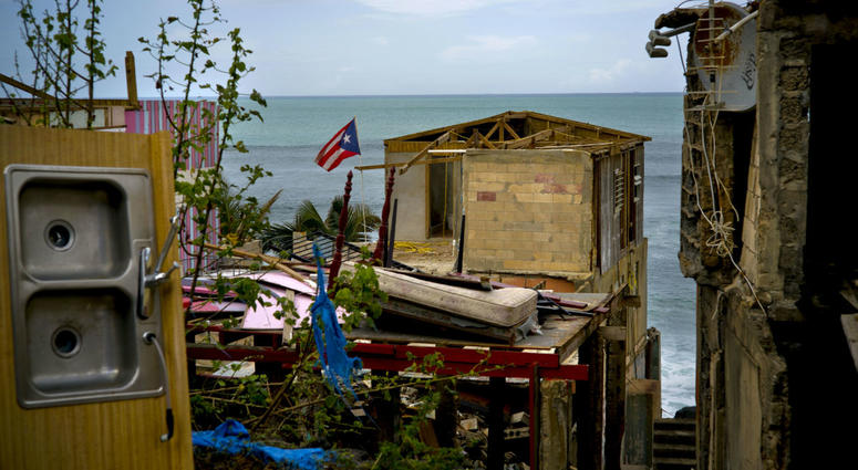 In this Oct. 5, 2017 file photo, a Puerto Rican national flag is mounted on debris of a damaged home in the aftermath of Hurricane Maria in the seaside slum La Perla, San Juan, Puerto Rico. In this Oct. 5, 2017 file photo, a Puerto Rican national flag is mounted on debris of a damaged home in the aftermath of Hurricane Maria in the seaside slum La Perla, San Juan, Puerto Rico.