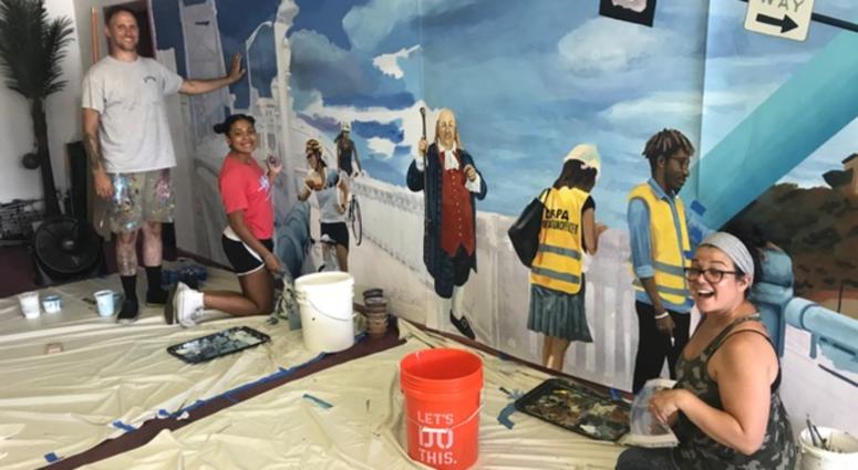 Local artists Brad Carney (left) and Melissa Mandel (right), along with student volunteers, paint a smaller version of the mural before they will paint the pedestrian and vehicular tunnels along Fifth Street under the Benjamin Franklin Bridge. Local artists Brad Carney (left) and Melissa Mandel (right), along with student volunteers, paint a smaller version of the mural before they will paint the pedestrian and vehicular tunnels along Fifth Street under the Benjamin Franklin Bridge.