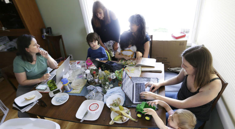 In this Wednesday, June 27, 2018, photo, a small group of stay-at-home mothers, with children at their sides, work to organize an immigration rally in Portland, Ore. In this Wednesday, June 27, 2018, photo, a small group of stay-at-home mothers, with children at their sides, work to organize an immigration rally in Portland, Ore.