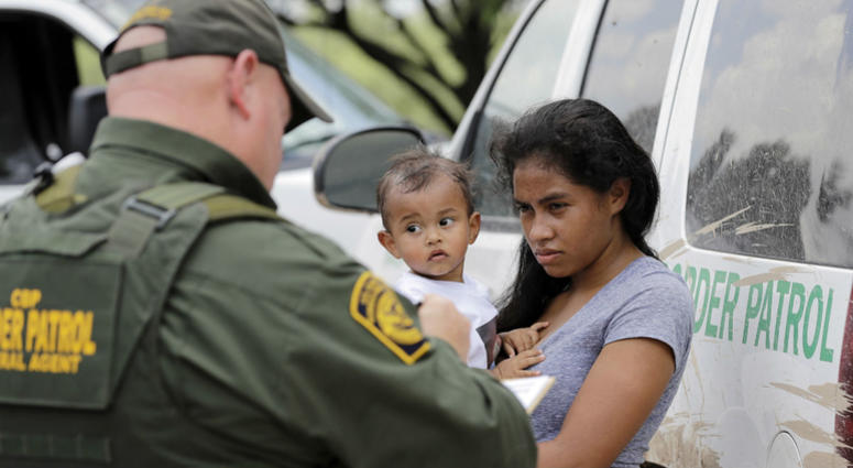 A mother migrating from Honduras holds her 1-year-old child as surrendering to U.S. Border Patrol agents after illegally crossing the border Monday, June 25, 2018, near McAllen, Texas. A mother migrating from Honduras holds her 1-year-old child as surrendering to U.S. Border Patrol agents after illegally crossing the border Monday, June 25, 2018, near McAllen, Texas.