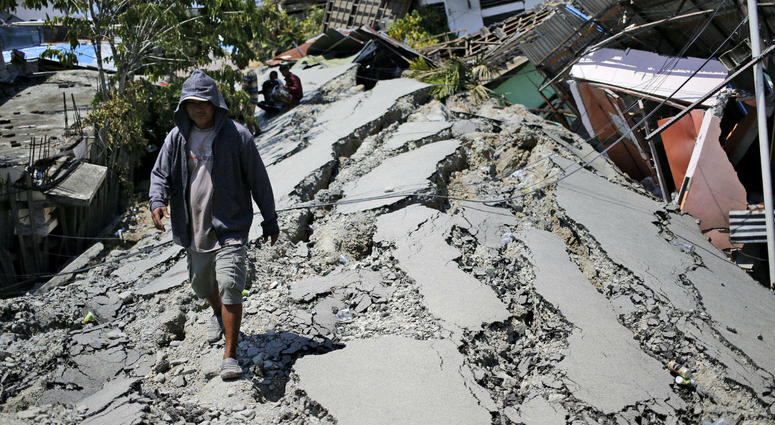 A man walks on a heavily damaged street due to the earthquake in Balaroa neighborhood in Palu, Central Sulawesi, Indonesia Indonesia, Tuesday, Oct. 2, 2018. A man walks on a heavily damaged street due to the earthquake in Balaroa neighborhood in Palu, Central Sulawesi, Indonesia Indonesia, Tuesday, Oct. 2, 2018.