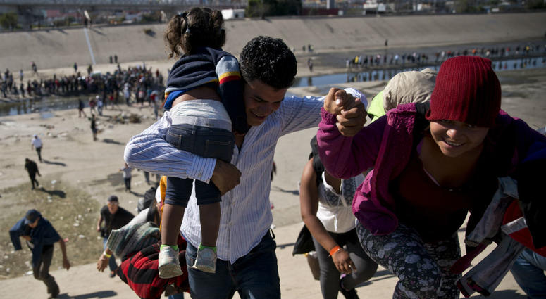Migrants walk up a riverbank at the Mexico-U.S. border after getting past a line of Mexican police at the Chaparral border crossing in Tijuana, Mexico, Sunday, Nov. 25, 2018, as they try to reach the U.S. Migrants walk up a riverbank at the Mexico-U.S. border after getting past a line of Mexican police at the Chaparral border crossing in Tijuana, Mexico, Sunday, Nov. 25, 2018, as they try to reach the U.S.