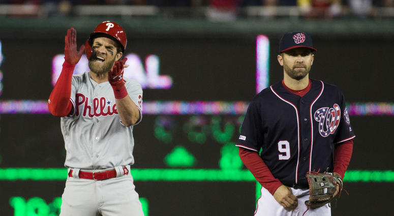 Philadelphia Phillies' Bryce Harper, left, celebrates his RBI hit while on second base with Washington Nationals second baseman Brian Dozier during the sixth inning of a baseball game at Nationals Park, Tuesday, April 2, 2019, in Washington. Philadelphia Phillies' Bryce Harper, left, celebrates his RBI hit while on second base with Washington Nationals second baseman Brian Dozier during the sixth inning of a baseball game at Nationals Park, Tuesday, April 2, 2019, in Washington.