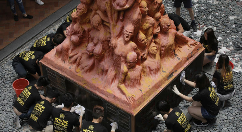 University students clean the "Pillar of Shame" statue, a memorial for those killed in the 1989 Tiananmen crackdown, at the University of Hong Kong, Monday, June 4, 2018. University of Hong Kong students clean the "Pillar of Shame" statue