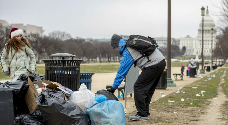 The Capitol building is visible as a man who declined to give his name picks up garbage and stacks it near a trash can during a partial government shutdown on the National Mall in Washington, Tuesday, Dec. 25, 2018. The Capitol building is visible as a man who declined to give his name picks up garbage and stacks it near a trash can during a partial government shutdown on the National Mall in Washington, Tuesday, Dec. 25, 2018.