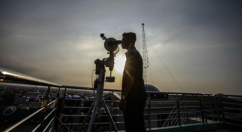 A man looks through a telescope to determine the sighting of the new moon to mark the start of the fasting month of Ramadan. A man looks through a telescope to determine the sighting of the new moon to mark the start of the fasting month of Ramadan.