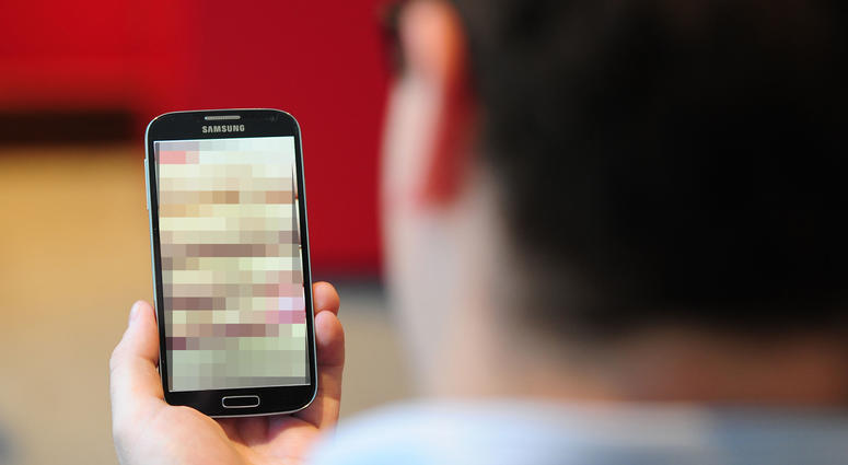 A man looking at a blurred photo on a cellphone. A man looking at a blurred photo on a cellphone.