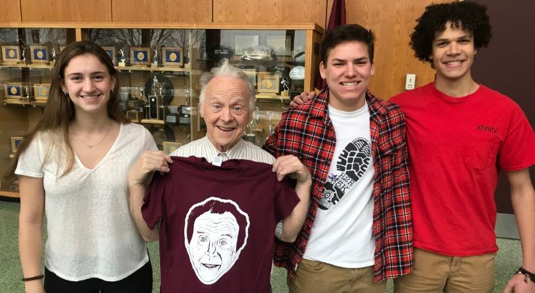John “Woody” McGoldrick (second from left) poses with his shirt and students, (from left) senior Becca Gable, freshman Ethan Weilheimer, and senior Josiah Campbell. John “Woody” McGoldrick (second from left) poses with his shirt and students, (from left) senior Becca Gable, freshman Ethan Weilheimer, and senior Josiah Campbell.