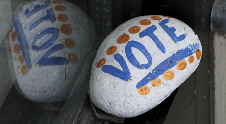 In this March 22, 2019, file photo, a stone painted with the word "VOTE" rests on the window sill of an art gallery in Peterborough, N.H. In this March 22, 2019, file photo, a stone painted with the word "VOTE" rests on the window sill of an art gallery in Peterborough, N.H.