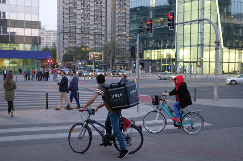 An Uber Eats meal delivery bicyclist arrives at an intersection in the city center on April 18, 2018 in Warsaw, Poland. Uber Eats is the biggest meal delivery service in the USA and is expanding aggressively internationally. (Photo by Sean Gallup/Getty I