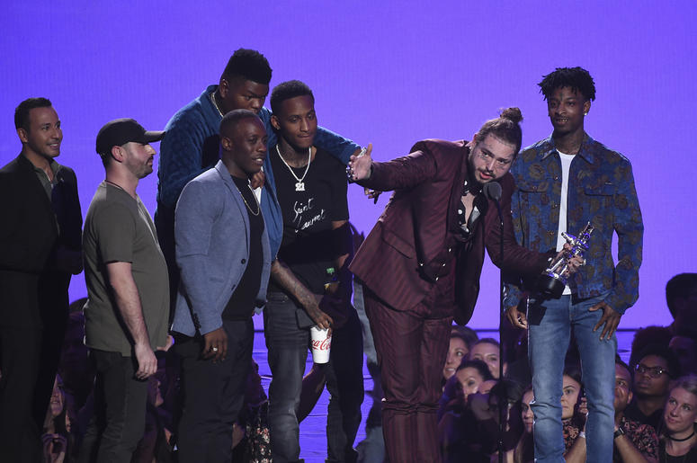 Post Malone and his entourage NEW YORK CITY - AUGUST 20: Post Malone, recipient of the award for Song of the Year, and 21 Savage speak onstage during the 2018 MTV Video Music Awards at Radio City Music Hall on August 20, 2018 in New York City. (Photo by Frank Micelotta/PictureGroup/Si