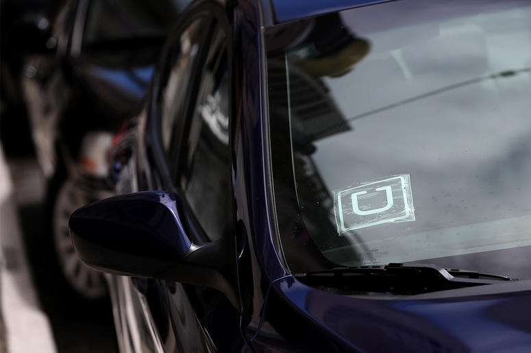 Uber logo is displayed in the window of a car SAN FRANCISCO, CA - JUNE 12: A sticker with the Uber logo is displayed in the window of a car on June 12, 2014 in San Francisco, California. The California Public Utilities Commission is cracking down on ride sharing companies like Lyft, Uber and Sidecar