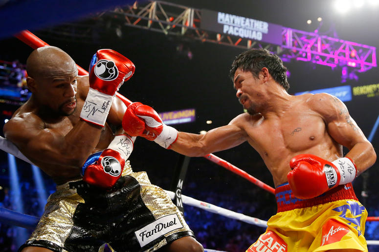 Floyd Mayweather Jr. and Manny Pacquiao LAS VEGAS, NV - MAY 02: Manny Pacquiao throws a right at Floyd Mayweather Jr. during their welterweight unification championship bout on May 2, 2015 at MGM Grand Garden Arena in Las Vegas, Nevada. (Photo by Al Bello/Getty Images)