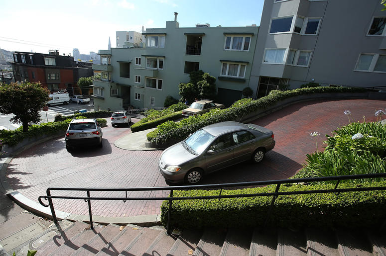 Lombard Street "The Crookedest Street In The World" SAN FRANCISCO, CA - MAY 20: Cars drive down Lombard Street on May 20, 2014 in San Francisco, California. The San Francisco Municipal Transportation Agency Board of Directors is considering a summer shutdown San Francisco's famed Lombard Street, known as t