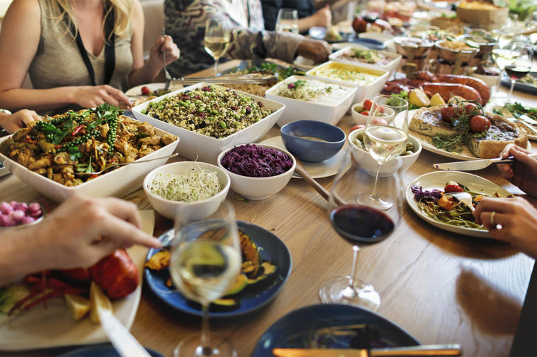 Table full of food and diners, dining Table full of food and diners, dining