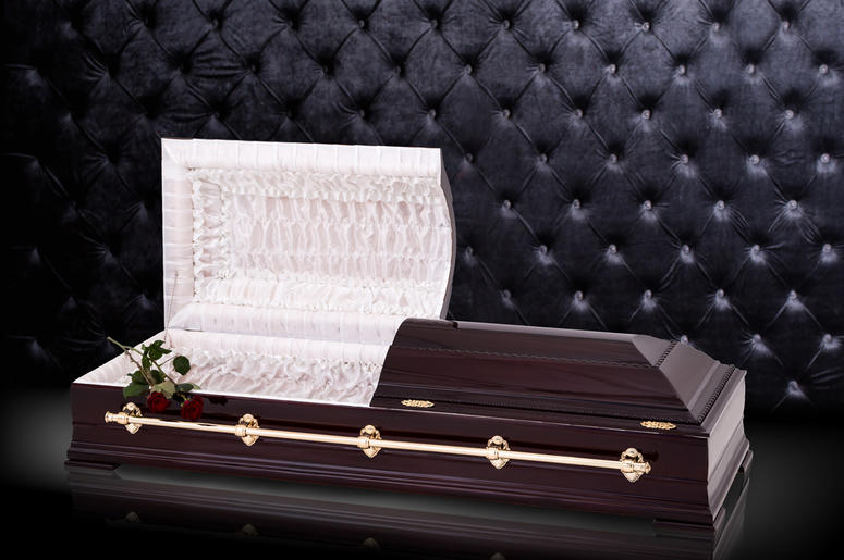 Opened wooden brown sarcophagus with a red roses isolated on gray luxury background. casket, coffin on royal background. Opened wooden brown sarcophagus with a red roses isolated on gray luxury background. casket, coffin on royalbackground. Ritual objects for burial. Conduct of the deceased on his last journey. Surrender body dust of the earth. Christian funeral ritual