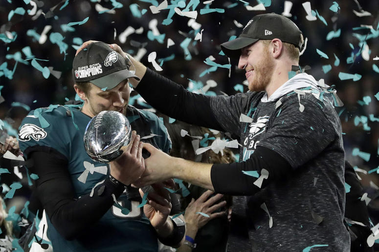 Philadelphia Eagles quarterback Carson Wentz, right, hands the Vincent Lombardi trophy to Nick Foles Philadelphia Eagles quarterback Carson Wentz, right, hands the Vincent Lombardi trophy to Nick Foles