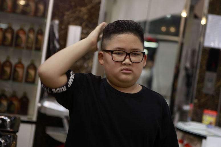 To Gia Huy, 9 checks his hair after having a Kim haircut in Hanoi, Vietnam, on Tuesday, Feb. 19, 2019. U.S. President Donald Trump and North Korean leader Kim Jong Un have become the latest style icons in Hanoi, a week before their second summit is to be