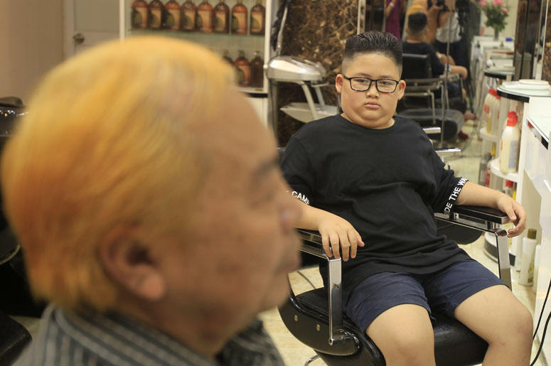 Le Phuc Hai, 66, left, and To Gia Huy, 9, have Trump and Kim haircuts in Hanoi, Vietnam, on Tuesday, Feb. 19, 2019. U.S. President Donald Trump and North Korean leader Kim Jong Un have become the latest style icons in Hanoi, a week before their second sum
