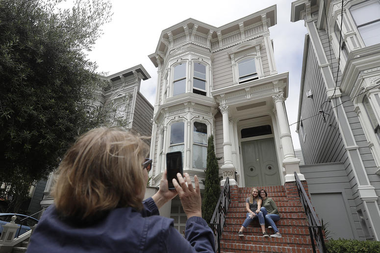 AP18198749815482 Aries Layton, seated left, and her aunt Kelsy Layton pose as Debra Layton, Aries' grandmother and Kelsy's mother, foreground, takes photos outside a Victorian home made famous by the television show "Full House" in San Francisco, Tuesday, July 17, 2018. T