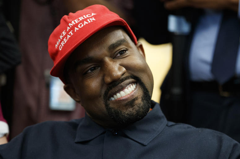AP18284625766631 Rapper Kanye West smiles as he listens to a question from a reporter during a meeting in the Oval Office of the White House with President Donald Trump, Thursday, Oct. 11, 2018, in Washington. (AP Photo/Evan Vucci)