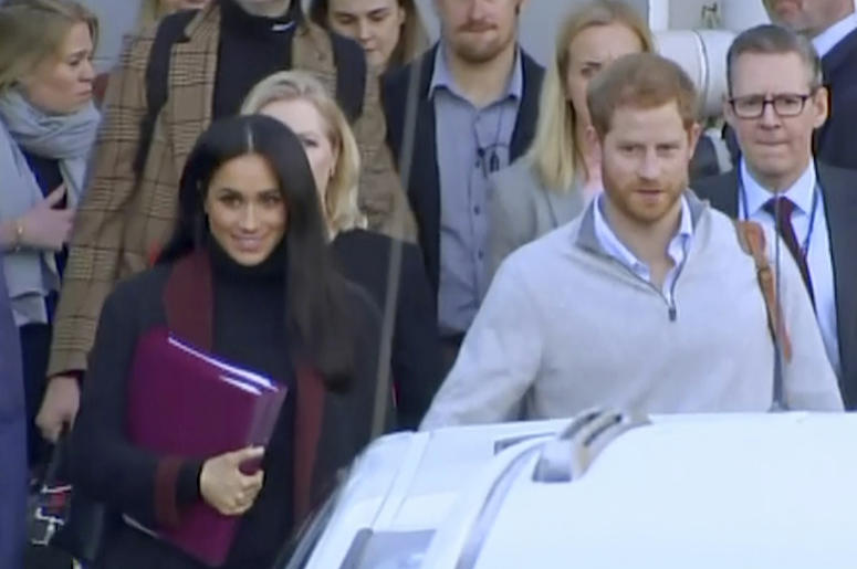 AP18288021432692 In this image made from video, Britain's Prince Harry, center right, and his wife Meghan Markle, left, Duke and Duchess of Sussex, approach a car at an airport in Sydney, Monday, Oct. 15, 2018. Prince Harry and his wife Meghan arrived in Sydney on Monday,