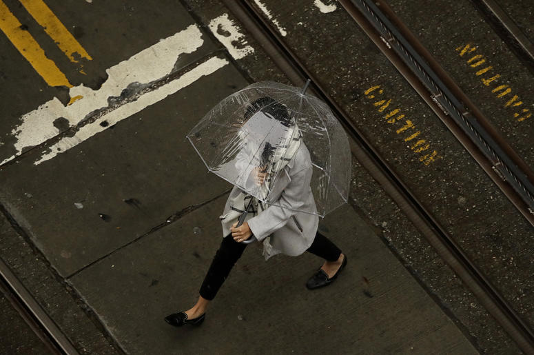 AP19017006526281 A woman walks in the rain while crossing an intersection in San Francisco, Wednesday, Jan. 16, 2019. A series of storms dropped rain up and down the state and snow in mountain regions this week, but the latest storm could be the strongest that Northern Ca