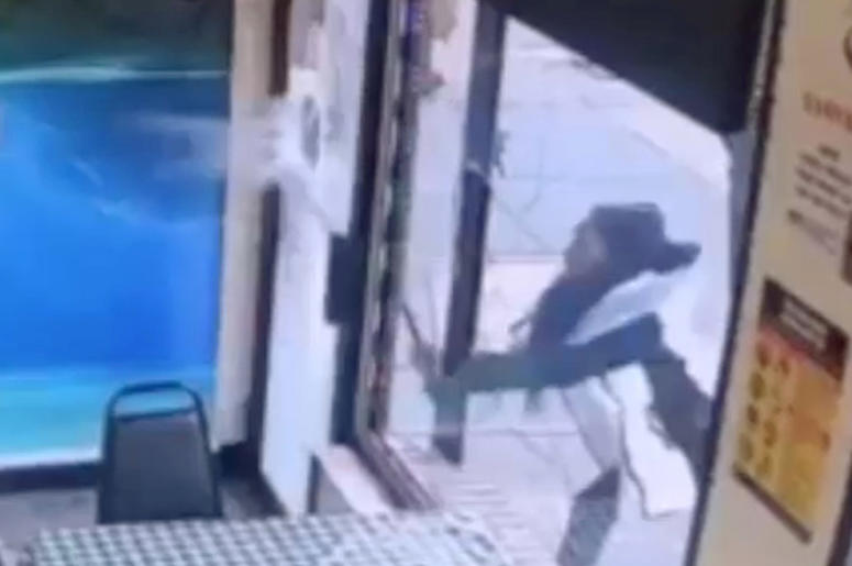 AP19040649910316 In this Jan. 15, 2019 image taken from surveillance video, a woman smashes the windows of "Back Home Restaurant" in the Bronx borough of New York. Police say that she became upset after ordering a patty and was told that the restaurant had run out of them
