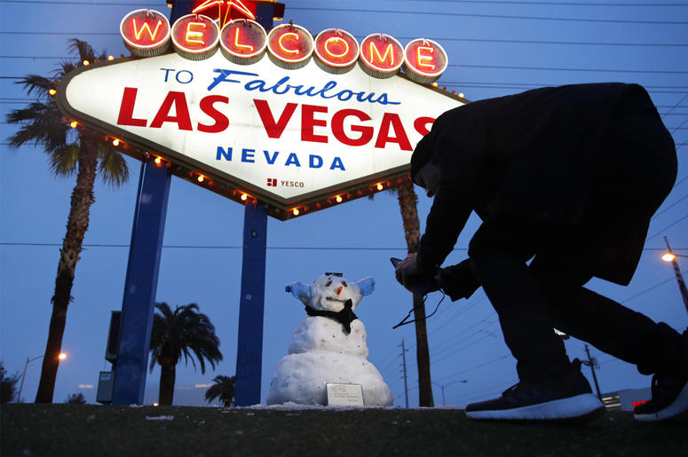 AP19052566507904 A man, who declined to give his name, takes a picture of a small snowman at the "Welcome to Fabulous Las Vegas" sign along the Las Vegas Strip, Thursday, Feb. 21, 2019, in Las Vegas. (AP Photo/John Locher)