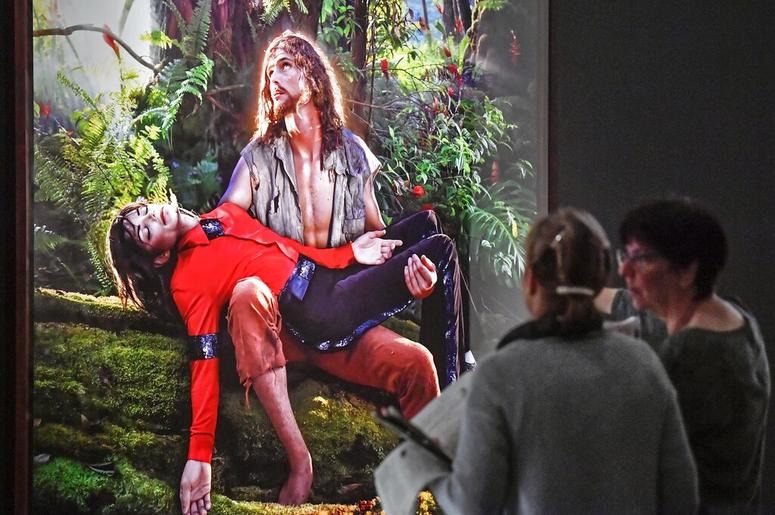 AP19080419247507 Visitors talk about the picture 'American Jesus: Hold me, carry me boldly' from US artist David LaChapelle at a preview of the exhibition 'Michael Jackson: On The Wall' at the Bundeskunsthalle museum in Bonn, Germany, Thursday, March 21, 2019. The exhibit
