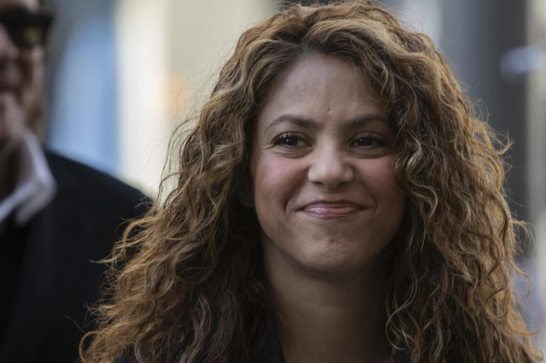 AP19086356853819 Colombian singers Shakira, right, and Carlos Vives, background, arrive at court in Madrid, Spain, Wednesday, March 27, 2019. (AP Photo)