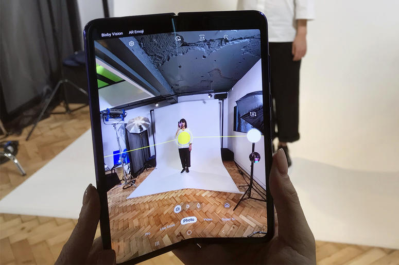 AP19106514275440 In this April 16, 2019, photo, a model holds a Samsung Galaxy Fold smart phone to her face, during a media preview event in London. (AP Photo/Kelvin Chan)