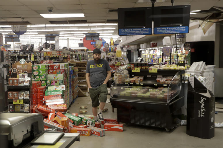 AP19187346904662 A worker steps over merchandise that is scattered on the floor of a Albertson's grocery store Saturday, July 6, 2019 following a earthquake in Ridgecrest, California. (AP Photo/Marcio Jose Sanchez)