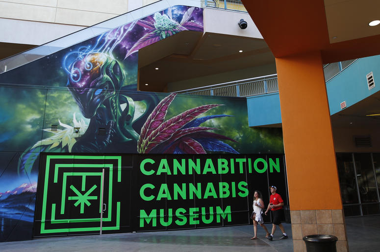 AP18263114971472 In this Tuesday, Sept. 18, 2018 photo, people walk by the Cannabition cannabis museum in Las Vegas. The museum celebrating all things cannabis with displays that include a glass bong taller than a giraffe and huggable faux marijuana buds is the newest tou