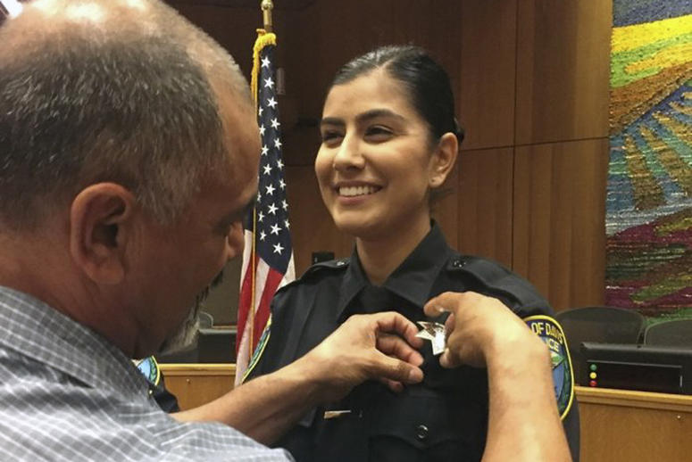 AP19011632271458 This Aug. 2, 2018 photo provided by Williams Pioneer Review shows Merced Corona, left, pins his daughter Natalie Corona's badge on her uniform during a swearing-in ceremony in Davis, Calif. Natalie Corona was shot and killed during a routine call Thursday