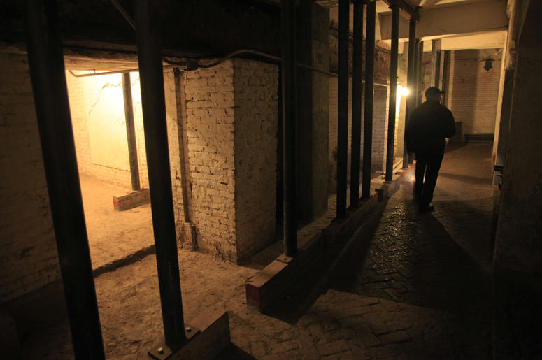 AP19065732605359 In this July 7, 2011, file photo, Jim Breeden of the Golden Gate National Parks Conservancy, walks through the dungeons below the main cell house during a night tour on Alcatraz Island in San Francisco. (AP Photo/Eric Risberg)