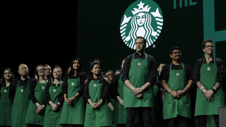 AP19079714317179 Starbucks baristas stand on stage, Wednesday, March 20, 2019, during Starbuck's annual shareholders meeting in Seattle. (AP Photo/Ted S. Warren)