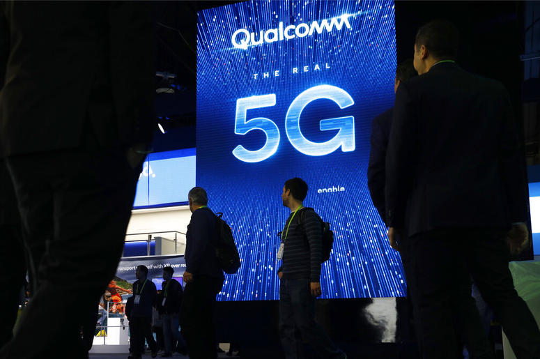 In this Jan. 9, 2019, file photo a sign advertises 5G at the Qualcomm booth at CES International in Las Vegas. Qualcomm and Apple drove declines in technology stocks on Wednesday, May 22. Qualcomm plunged following a federal judge's ruling against the chi