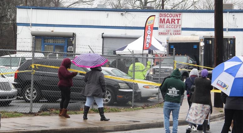 Onlookers gathered outside the Lee Street auto retail shop where 2 men were found dead inside an SUV Onlookers gathered outside the Lee Street auto retail shop where 2 men were found dead inside an SUV