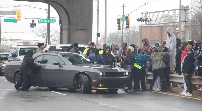 Onlookers surround a vehicle that police had allowed to leave the scene where 2 men were found dead inside a vehicle Onlookers surround a vehicle that police had allowed to leave the scene where 2 men were found dead inside a vehicle