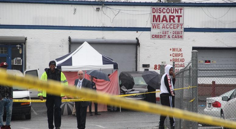 A blue and white tent with red tarp surrounds the SUV in which the bodies of two men were found outside an auto sales shop A blue and white tent with red tarp surrounds the SUV in which the bodies of two men were found outside an auto sales shop