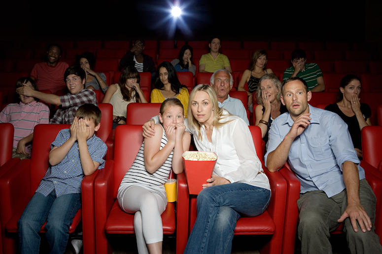 A family enjoys a movie in a theater A family enjoys a movie in a theater