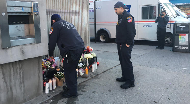 Two FDNY EMTs lay flowers at a makeshift memorial where two children were killed in a crash in Park Slope, Brooklyn. Brooklyn Crash Memorial