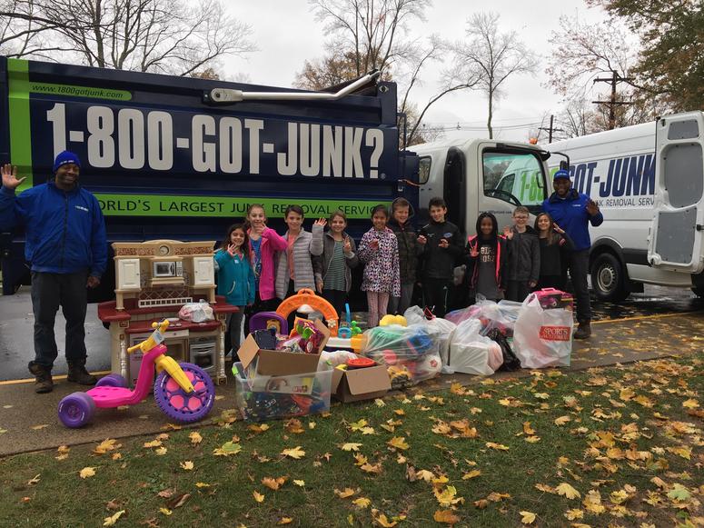 1-800-GOT-JUNK volunteers celebrate the 300,000th toy pickup