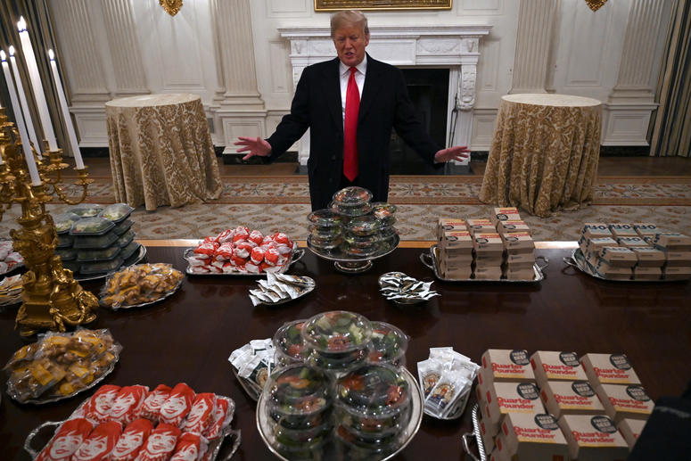 President Donald Trump talks to the media about the table full of fast food in the State Dining Room of the White House in Washington, Monday, Jan. 14, 2019, for the reception for the Clemson Tigers. Trump McDonalds
