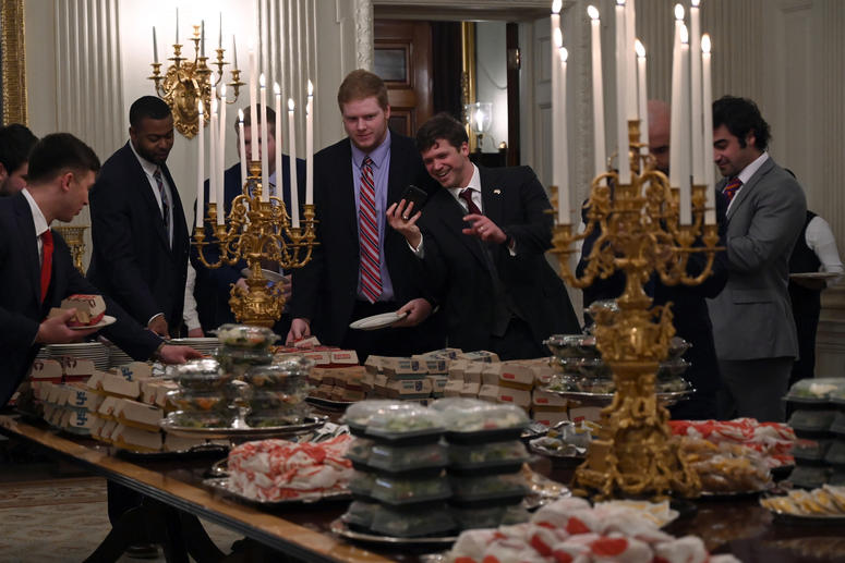 Guests attending a reception for the Clemson Tigers grab fast food sandwiches in the State Dining Room of the White House in Washington, Monday, Jan. 14, 2019. Trump McDonalds