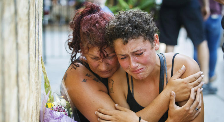 Desirae Shapiro, 19, right, and her mother, Gina Shapiro, friends of 18-year-old Danforth shooting victim Reese Fallon, mourn after visiting a makeshift memorial, Monday, July 23, 2018, in Toronto, remembering the victims of the mass shooting. Toronto Shooting Mourning