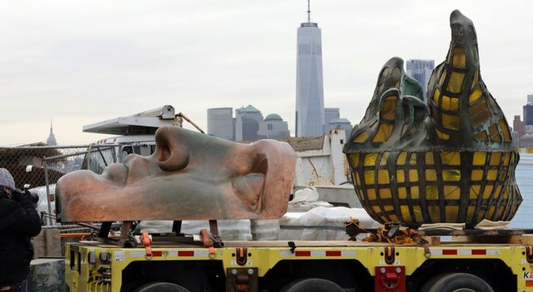 The original torch of the Statue of Liberty, and a replica of her face, rest on a hydraulically stabilized transporter, Thursday, Nov. 15, 2018 in New York. Statue of Liberty