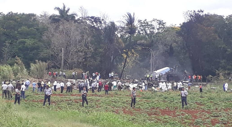 Rescue and search workers on the site where a Cuban airliner with 104 passengers on board plummeted into a yuca field just after takeoff from the international airport in Havana, Cuba, Friday, May 18, 2018. Cuba Plane Crash